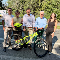 Fünf Personen stehen mit einem Fahrrad vor einer Baustelle in Oberösterreich.
