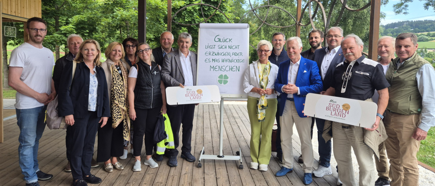 Südburgenland: Gruppe mit Menschen vor Flipchart mit Spruch und Kleeblatt