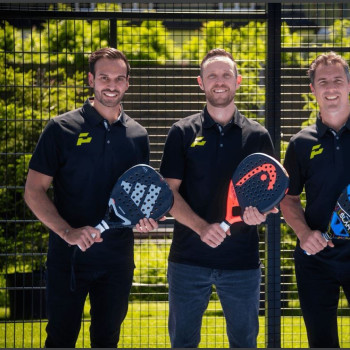 Padel-Trainer mit Schlägern vor einem Zaun in Wien