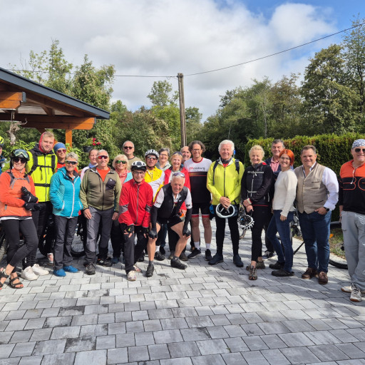 Radfahrgruppe in Oberösterreich mit Radfahrern und Radfahrerinnen vor einem Gebäude