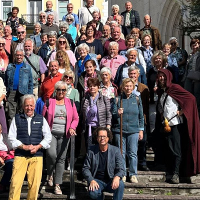 Gruppe von Wanderern in Österreich auf einer Steintreppe vor einem Gebäude