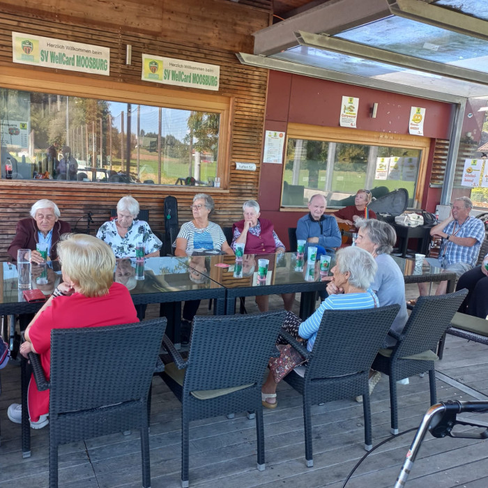 Senioren sitzen im Freien an einem Tisch in Moosburg, Niederösterreich