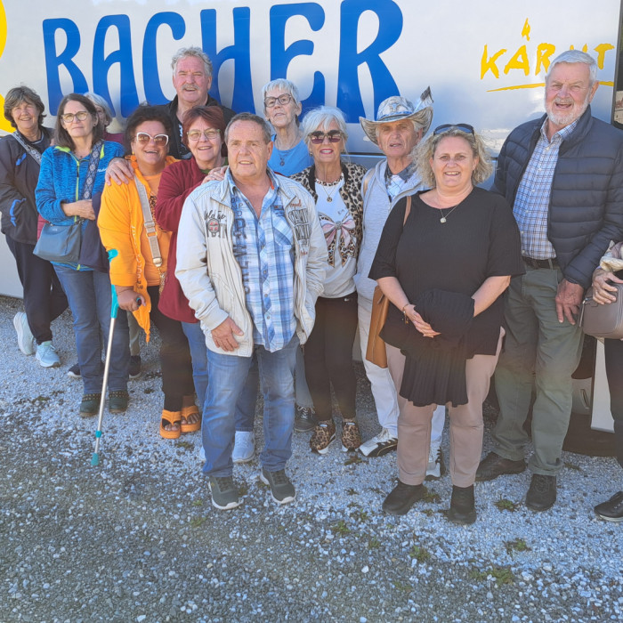 Gruppe von Reisenden vor einem Reisebus mit Aufschrift "BACHER" und "KÄRNTEN"